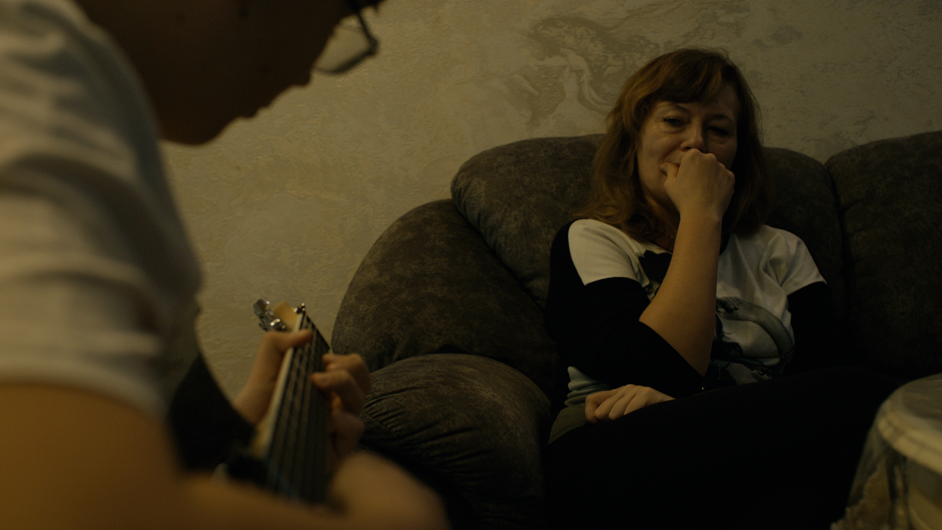 Sviatoslav plays guitar during an evening at home.